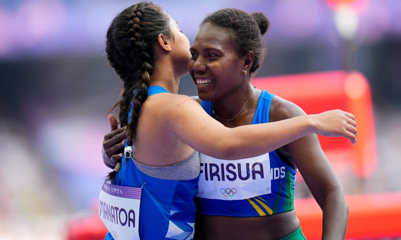 Sharon Firisua of the Solomon Islands and Temalini Manatoa of Tuvalu embrace after their 100m heat in Paris. Photograph: Petr David Josek/AP (Image obtained at theguardian.com)