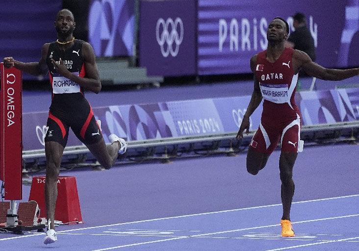 QUICK LAP: Trinidad and Tobago’s Jereem “The Dream” Richards, left, finishes his Olympic Games men’s 400 metres first round heat in 44.31 seconds at the Stade De France, in Paris, yesterday. Richards was second in the race. Qatar’s Ammar Ibrahim, right, clocked a personal best of 44.66 to secure fourth spot.   —Photo: BRENT STUBBS (Image obtained at trinidadexpress.com)