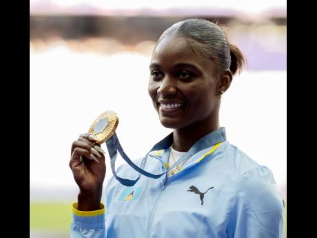 Gladstone Taylor Olympic 100 metres champion Julien Alfred of St Lucia displays her gold medal during the medal ceremony for the event at the Stade de France in Paris, France, yesterday. (Image obtained at jamaica-gleaner.com)