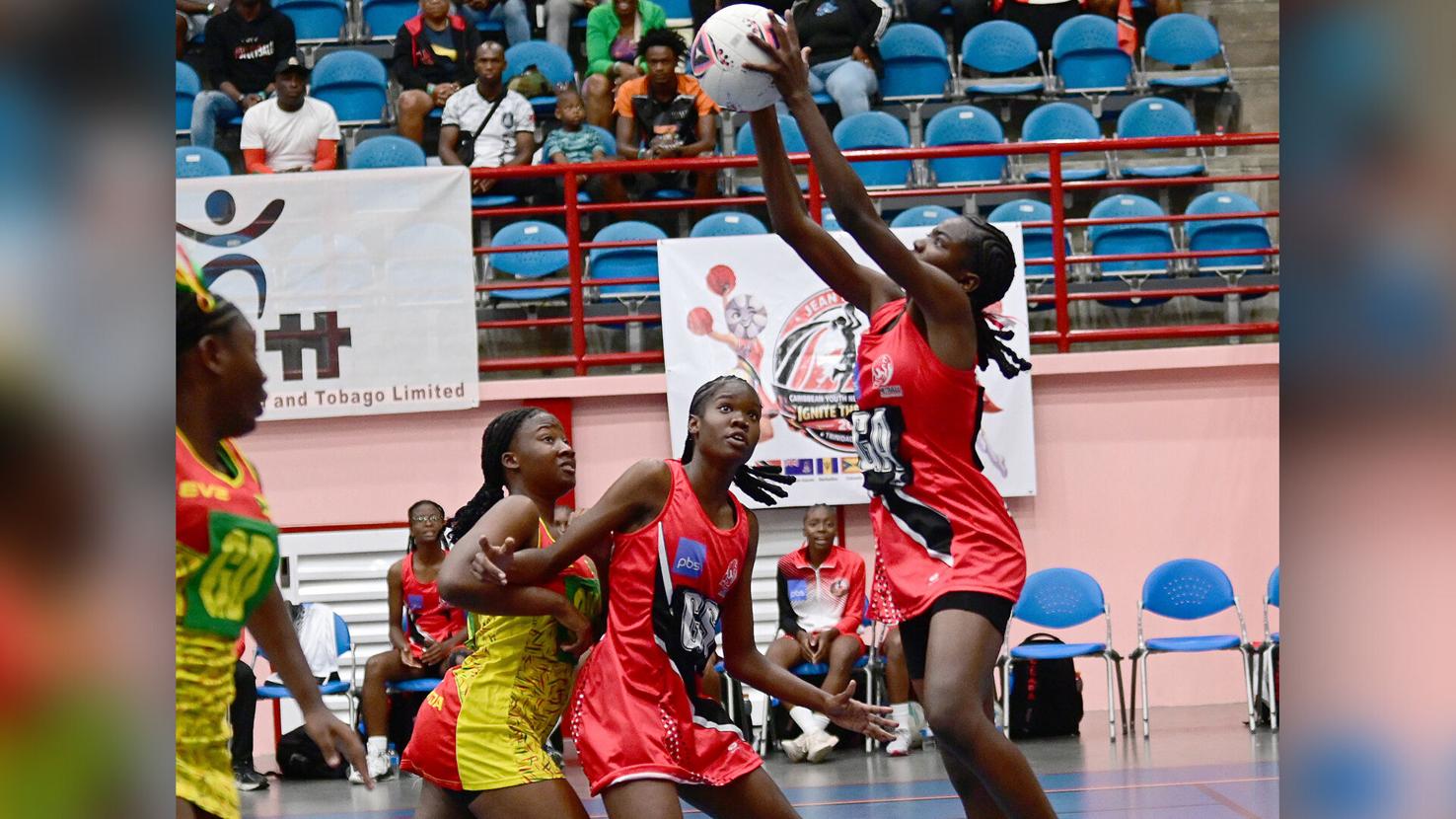 CLEAN CATCH: Trinidad and Tobago goal attack Zewditu Alexander, right, collects the ball cleanly while teammate Venus Kirk, centre, provides a screen against an opposing player during their team’s match against Grenada in the Jean Pierre Caribbean Youth Netball Championships, at the UWI Sports and Physical Education Centre (UWI SPEC) in St Augustine, Sunday night. T&T won 32-12. —Photo: JERMAINE CRUICKSHANK (Image obtained at trinidadexpress.com)